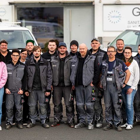 Das Team von Gerdes, bestehend aus Männern und Frauen, posiert vor einem weißen Lieferwagen, umgeben von einem freundlichen Ambiente.